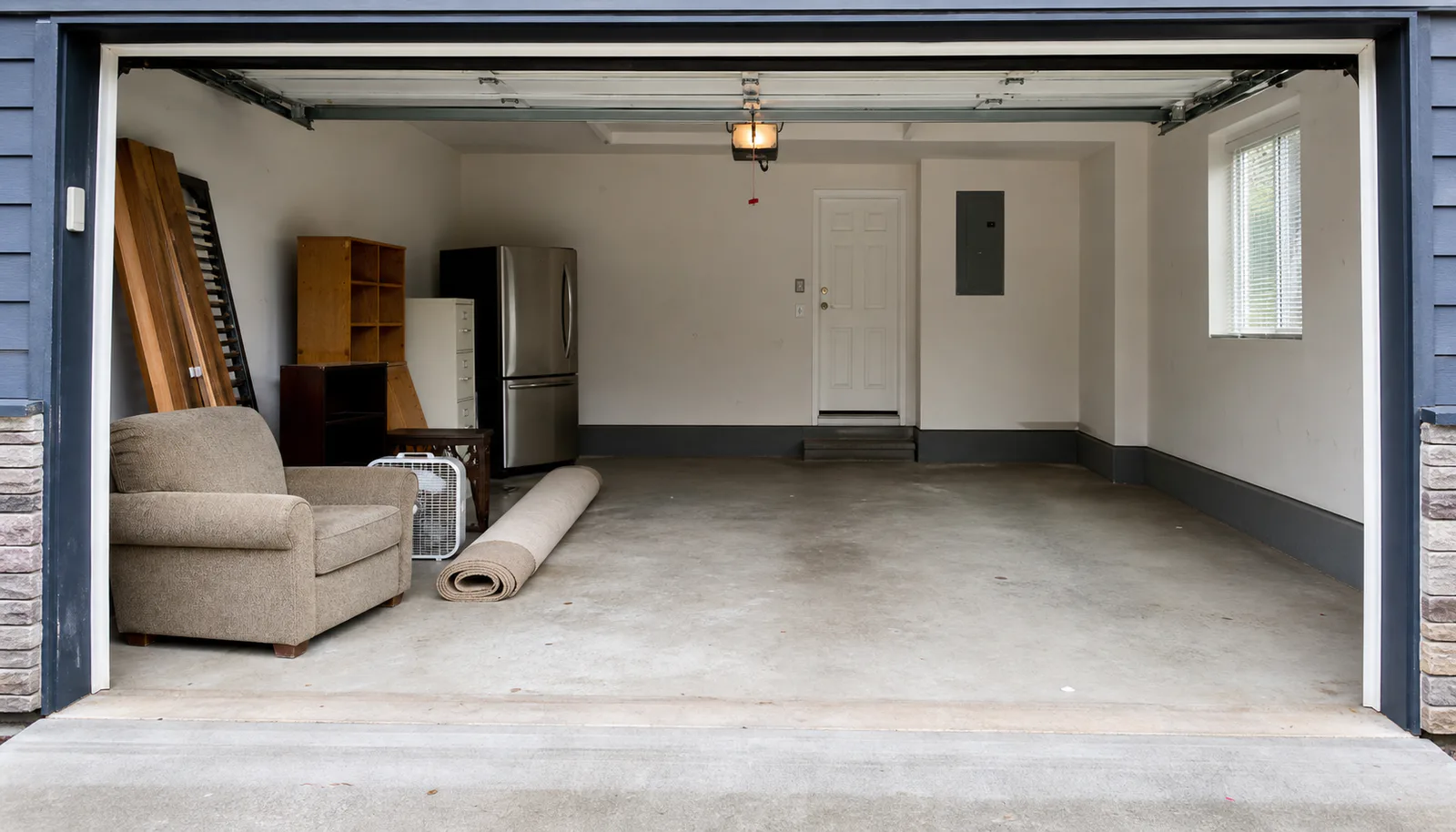Generic residential property-preparation setting with furniture staged in a mostly clear garage