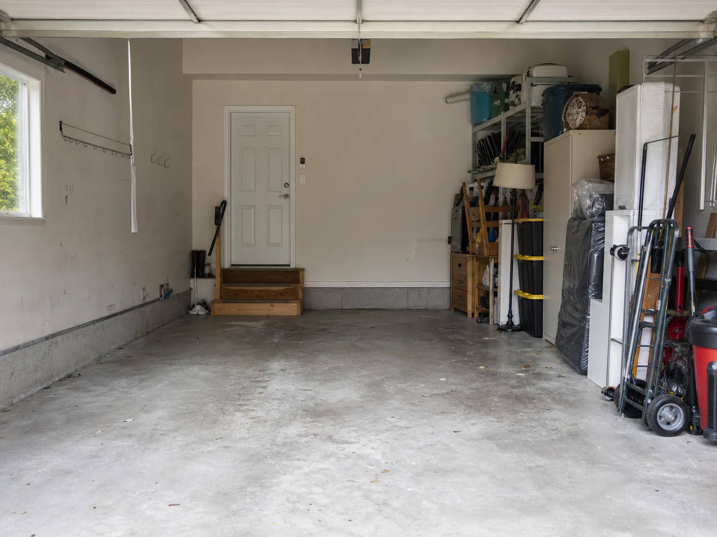 Household furniture and boxes staged beside a clear garage access path