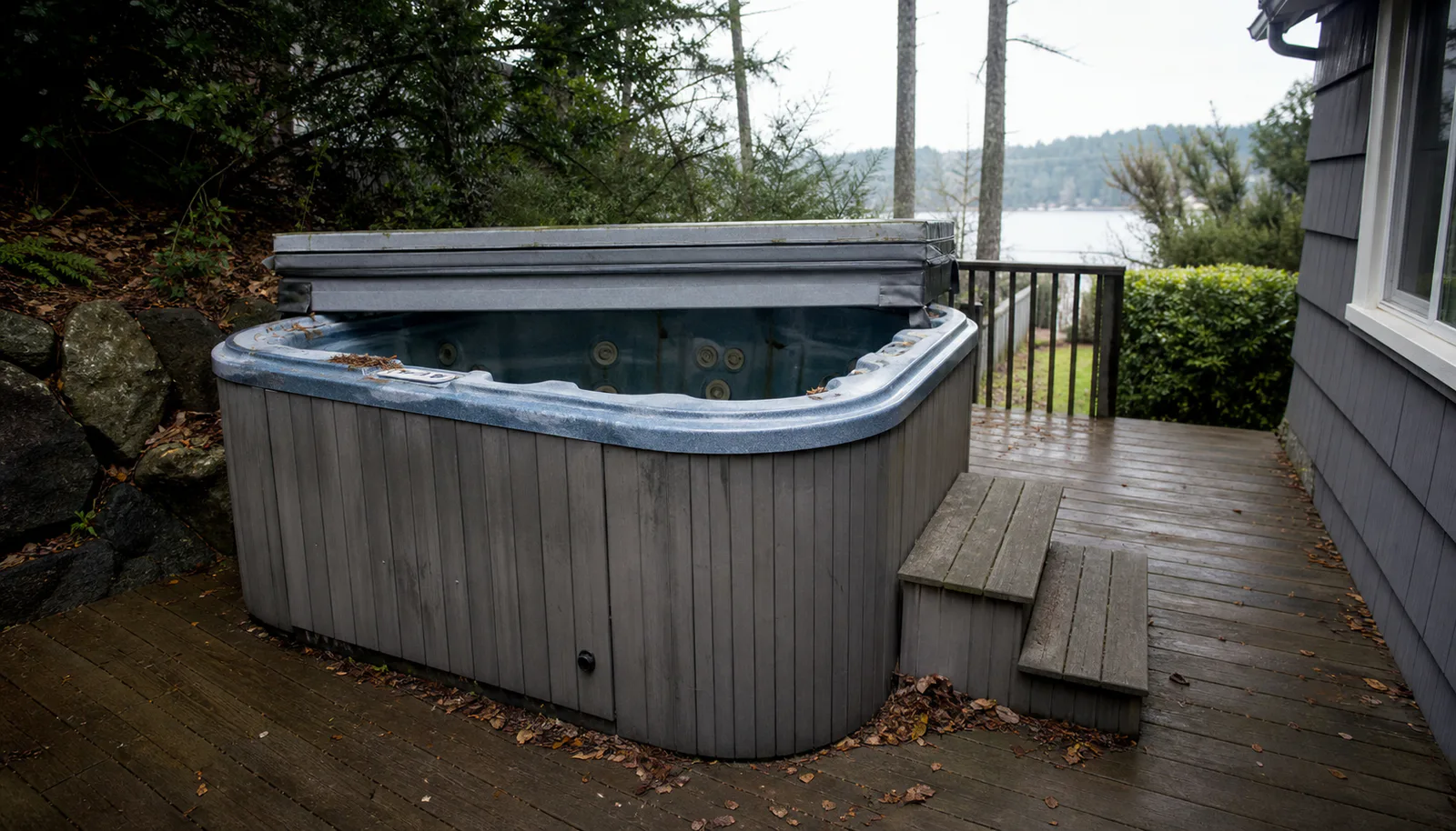 Hot tub on a residential deck with nearby stairs and side access