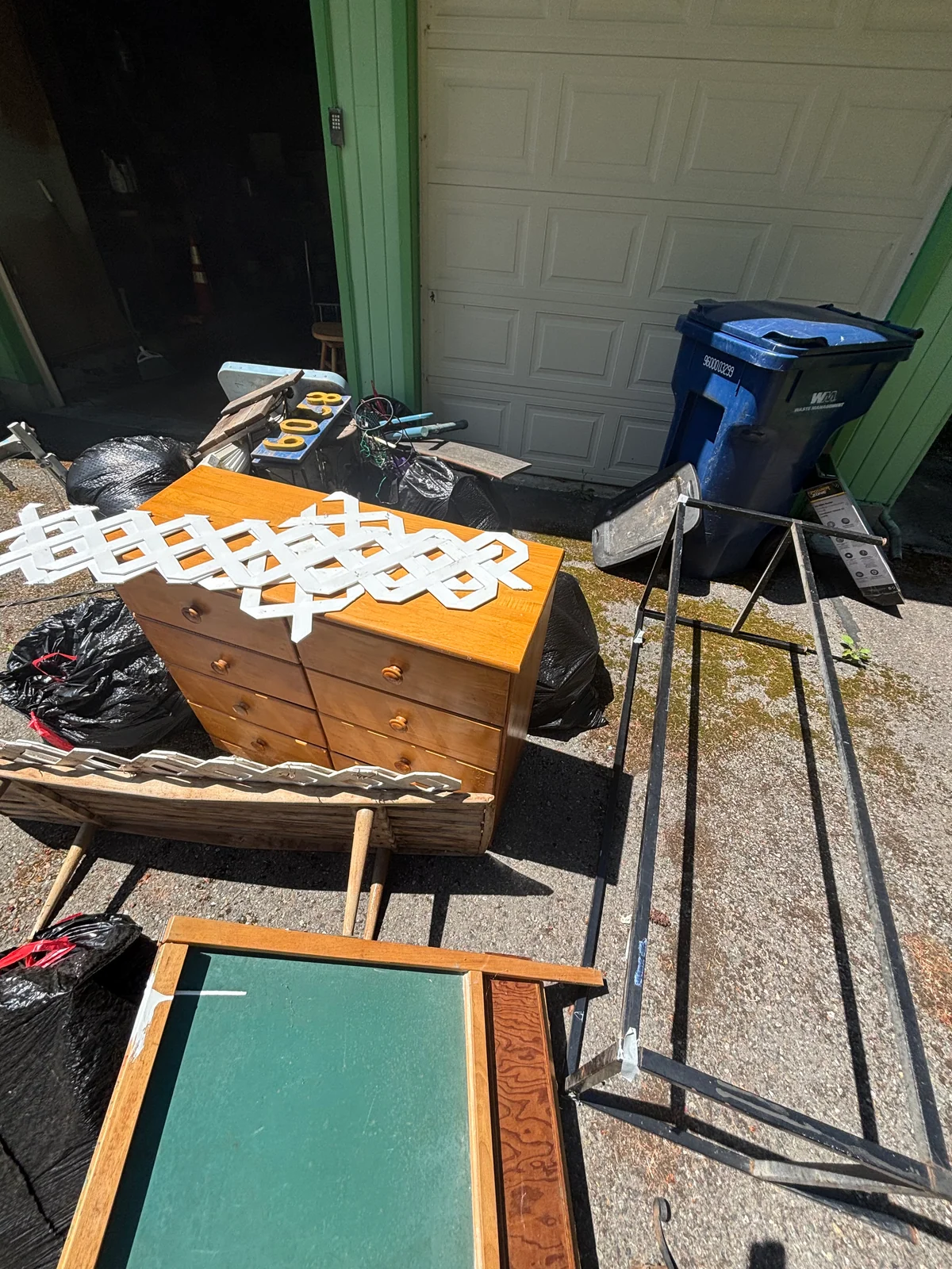 A second view of furniture and household items staged for curbside pickup