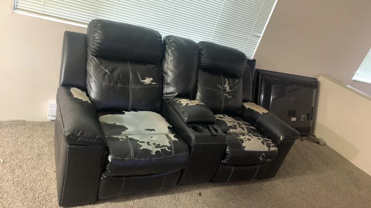 Black reclining loveseat documented for furniture pickup