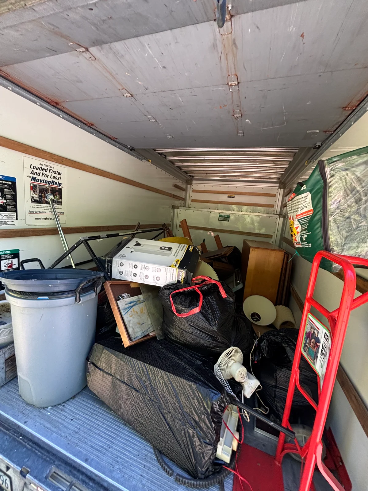 Furniture, bags, and household items loaded into a removal truck