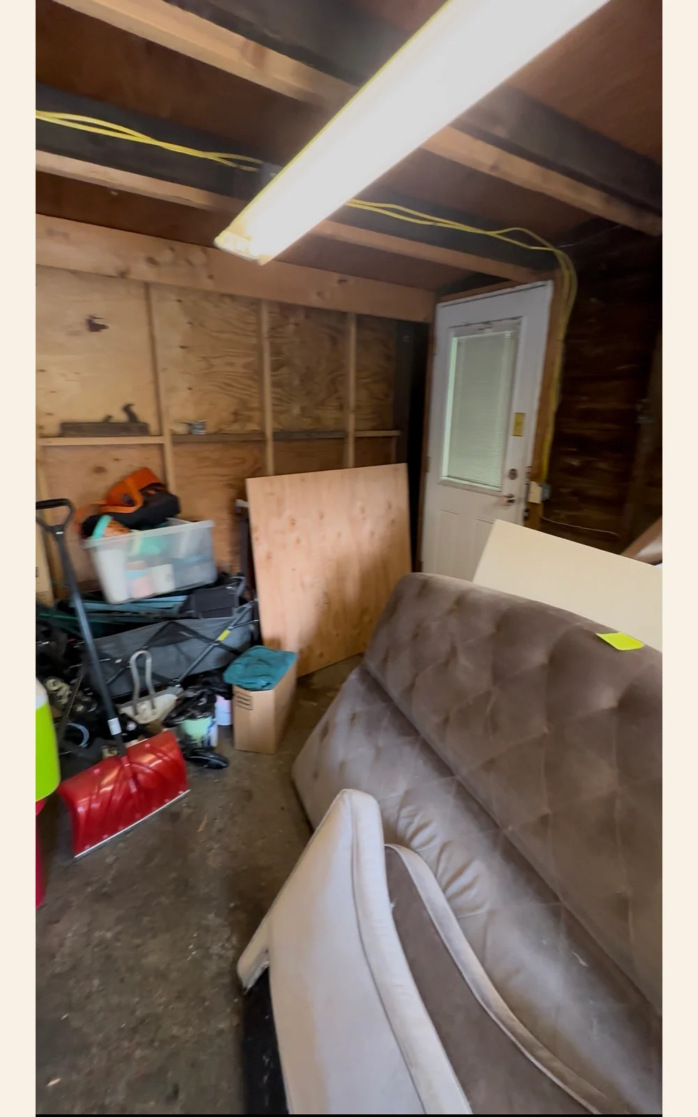 Sofa and household contents in a garage before pickup